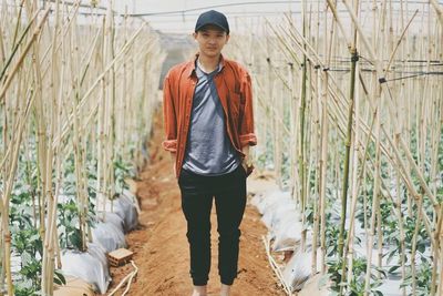 Full length portrait of man standing in greenhouse