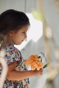 Side view of girl holding flowers