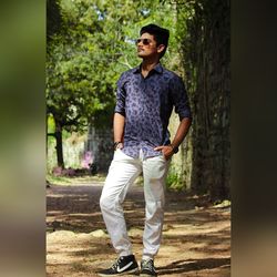 Full length of young man standing against trees