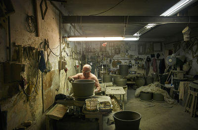 Potter in workshop working on large terracotta vase