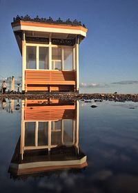 Reflection of building in lake against sky