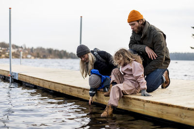 Man and woman with son and daughter on jetty at lake