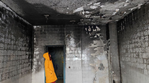 Low angle view of man standing in abandoned building