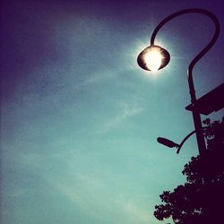 Low angle view of illuminated street light against sky