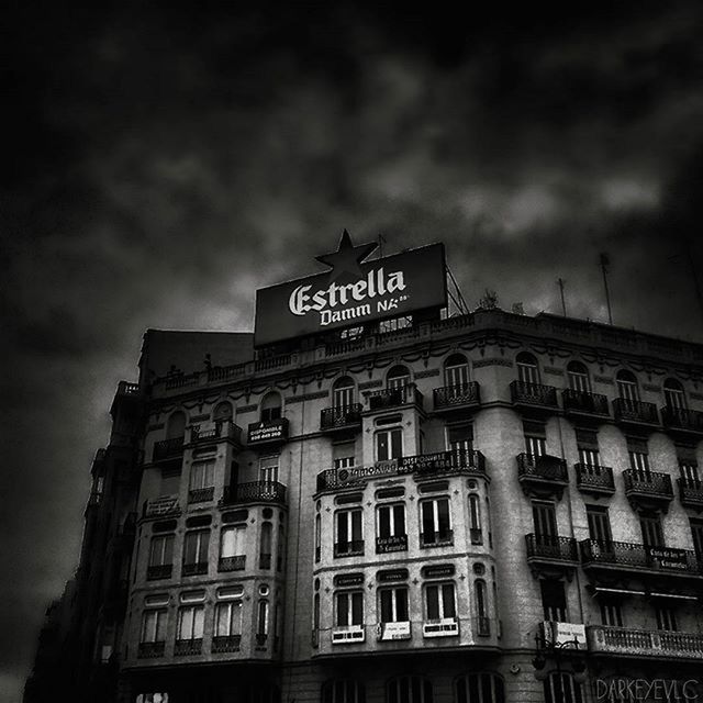 architecture, building exterior, built structure, low angle view, sky, window, text, building, western script, city, cloud - sky, cloudy, facade, outdoors, no people, day, cloud, residential building, exterior, city life