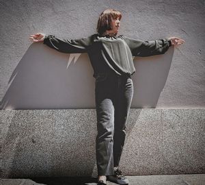 Rear view of woman standing against wall