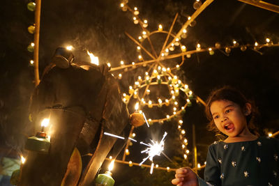 Low angle view of happy girl holding sparkler