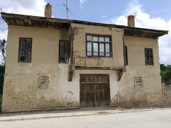 Exterior of old building by street against sky