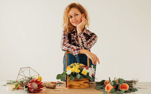 Portrait of smiling young woman against white background