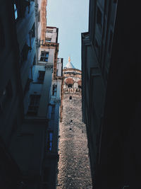 Narrow alley amidst buildings in city against sky