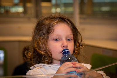 Close-up of girl drinking water at restaurant