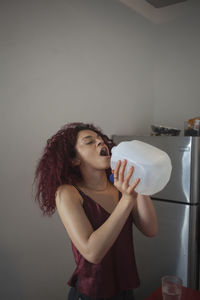 Young woman drinking water from a large bottle