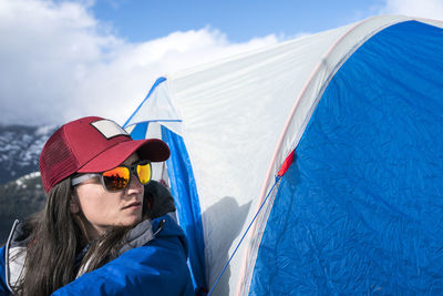 Portrait of a woman in a red hat sitting in front of her tent at base camp, mt. baker