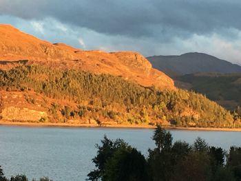 Scenic view of calm lake against rocky mountains