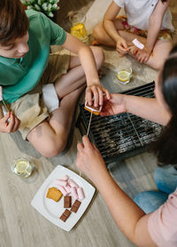 Mother eating food with children at home