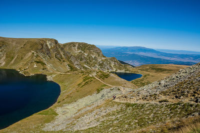 Scenic view of landscape and mountains against blue sky