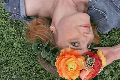 High angle view portrait of woman lying on grassy field