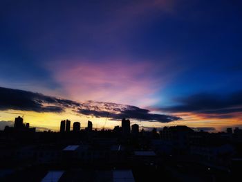 High angle view of silhouette buildings against sky during sunset