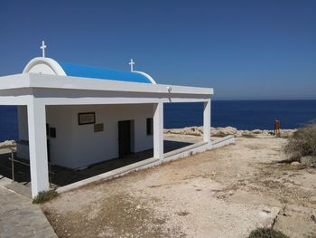 Built structure on beach against clear blue sky