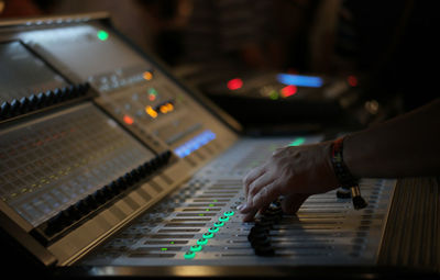 Cropped hands mixing music with sound recording equipment in studio