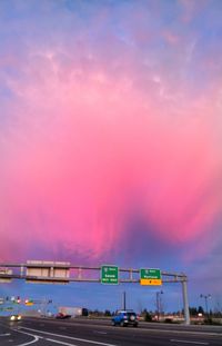 Road sign against sky during sunset