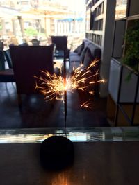 Close-up of illuminated lamp on table in city at night