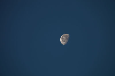 Low angle view of moon against blue sky