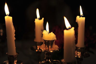 Close-up of lit candles in darkroom