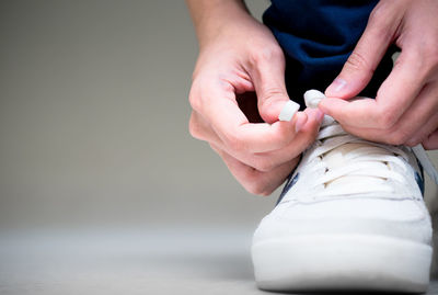 Low section of person tying shoelace