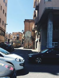 Cars on city street against clear sky