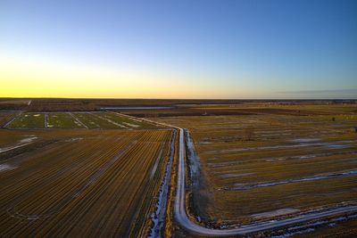 Aerial view of agricultural field against clear sky during sunset