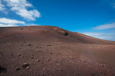 Scenic view of desert against blue sky