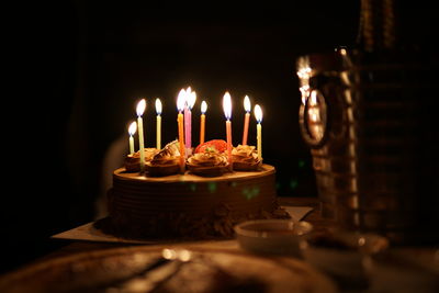 Close-up of illuminated candles on cake