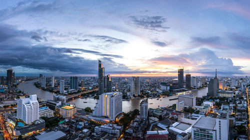 High angle view of city buildings against cloudy sky