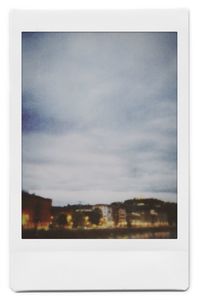 Buildings against sky seen through glass window