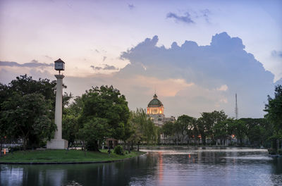 View of buildings at waterfront against cloudy sky