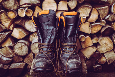 Woodcutter boots and stack of firewood woodcutter equipment and tools hard work outdoor