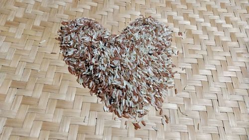 High angle view of heart shape made with rice on wicker