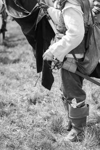 Low section of man standing on field