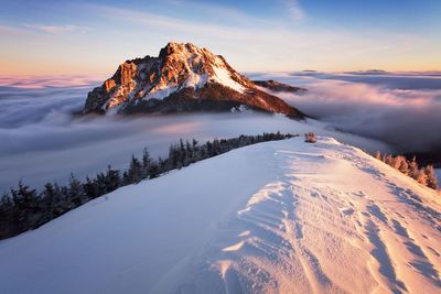 Scenic view of snowcapped mountains against sky during sunset