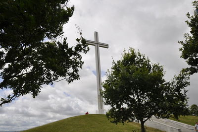 Low angle view of cross on field against sky