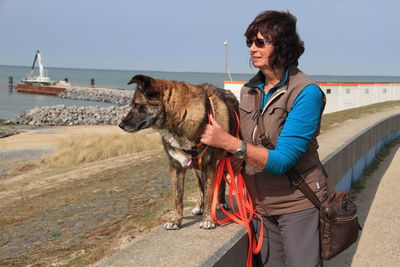 Woman and pet dog by the beach