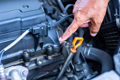 Cropped hands repairing car engine