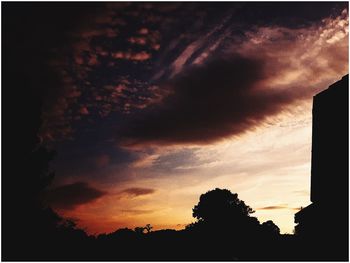 Silhouette of trees against dramatic sky