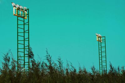 Low angle view of communications tower against clear blue sky