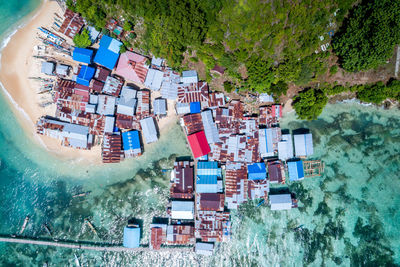 High angle view of houses by sea against trees