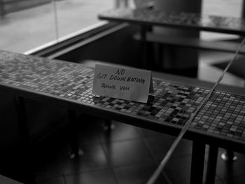 Close-up of information sign on table