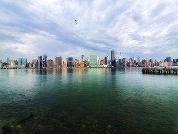 Scenic view of river by buildings against sky