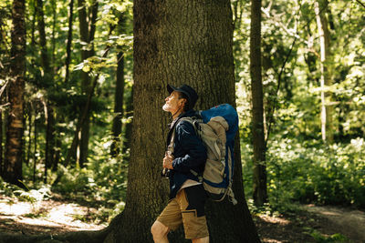 Rear view of woman standing in forest
