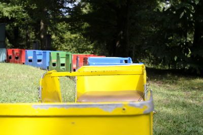 Close-up of yellow garbage can on field